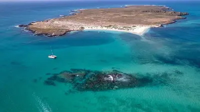 an island with a sail boat in the water at Beachapartment fully serviced in Sal Rei