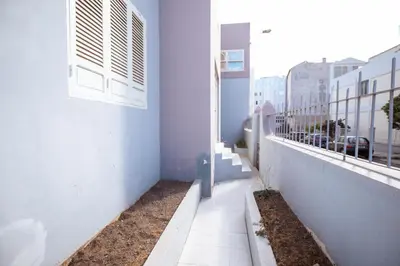 a corridor of a white building with a window at Maya Mindelo 2 in Mindelo