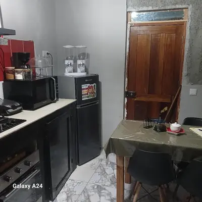 a kitchen with a stove and a microwave and a table at Casa brunosky in Mindelo