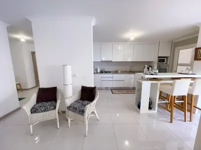 a kitchen with white cabinets and a table and chairs at Marel Bliss Apartments T2 Camila in Mindelo