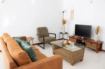 a living room with a couch and a tv at Marel Bliss Apartments T2 Lorena in Mindelo