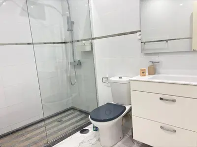 a white bathroom with a toilet and a shower at Relax in Praia in comfort in Praia