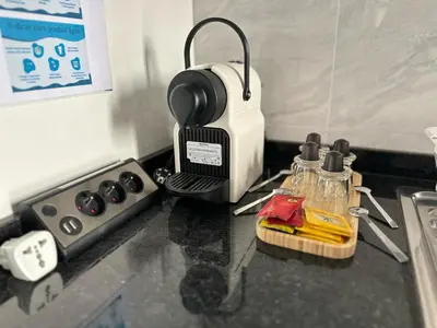 a kitchen counter with a stove and a sink at Cozy Flat in Praia