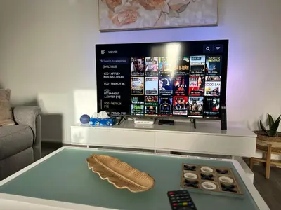 a living room with a table with a remote control at Cozy Flat in Praia