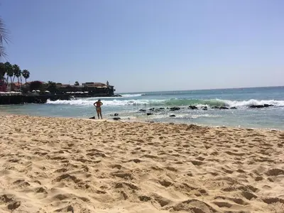 a man standing on a sandy beach near the ocean at Island Retreat in Santa Maria