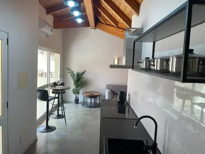 a kitchen with a counter and some chairs and a table at Island Retreat in Santa Maria