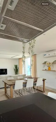 a dining room with a table and white chairs at Laginha Paradise III in Mindelo