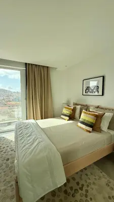 a bedroom with a large bed with a large window at Laginha Paradise III in Mindelo