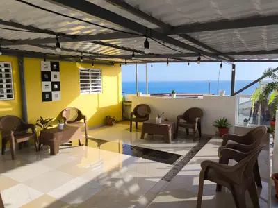 a patio with chairs and tables and a view of the ocean at Ocean view Apartment 2 in Cidade Velha
