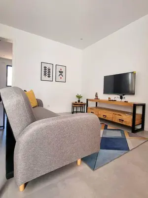 a living room with a couch and a flat screen tv at R3 Apartments - Laginha in Mindelo