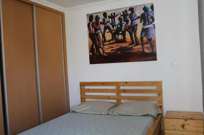 a bedroom with a bed and a painting on the wall at Paradise in Praia
