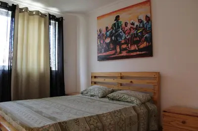 a bedroom with a bed and a painting on the wall at PR T2 TerceiroB in Praia
