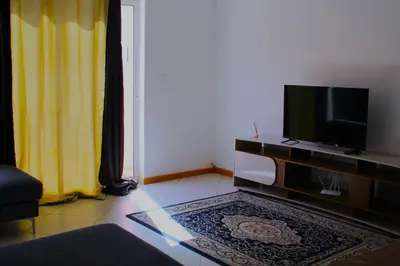 a living room with a flat screen tv on a entertainment center at PR T2 TerceiroB in Praia