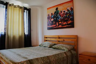 a bedroom with a bed and a painting on the wall at PR T1 TerceiroB in Praia