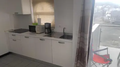 a small kitchen with a sink and a microwave at Apartamento T1 - Hotel Las Rochas in Mindelo