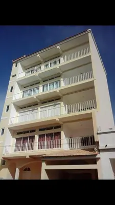 a tall white building with balconies on the side of it at Casa Ramanda in Tarrafal