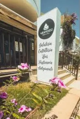 a sign in front of a building with flowers at Leme Bedje Residence in Santa Maria