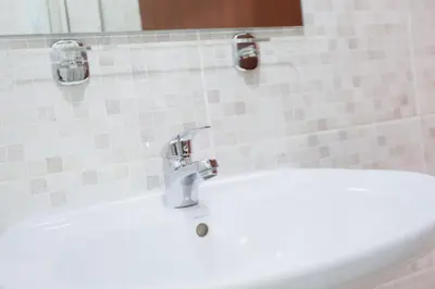 a bathroom sink with a faucet on a tile wall at Aaparthotel Book a Taxi Group in Prainha