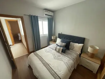 a bedroom with a large bed with a blue headboard at Our Happy Place Prainha in Praia