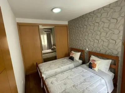 two beds in a small room with a mirror at Our Happy Place Prainha in Praia