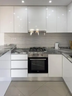 a kitchen with white cabinets and a stove at Spacious 2 bdr apt in Achada St Antonio - LCGR in Praia