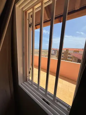a window with a view of the beach at Holiday Properties Prestige Apartments in Santa Maria