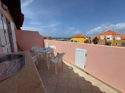 a patio with a table and chairs on a balcony at Holiday Properties Prestige Apartments in Santa Maria
