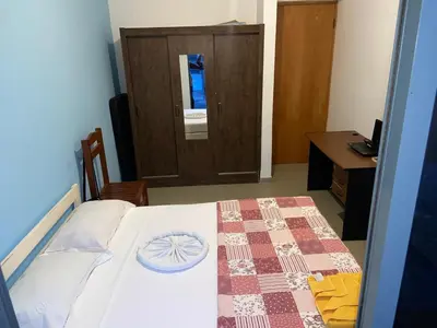 a bedroom with a bed with a table and a door at Kaza Horta in Tarrafal