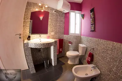 a purple bathroom with a toilet and a sink at Cala da Lua apartments in Sal Rei