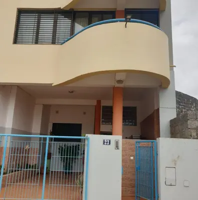 a house with a blue gate in front of a building at Imperio in Praia