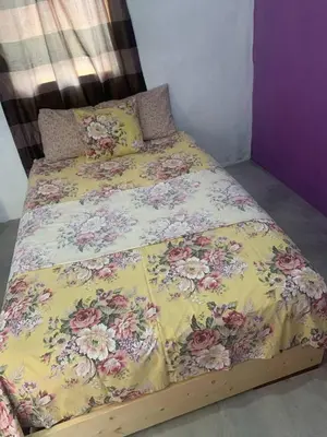 a bed with a yellow comforter with flowers on it at Pousada casa Eurico in Portela