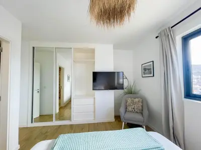 a bedroom with a bed and a mirror and a chair at Helena - Marel Bliss Apartments T3 in Mindelo