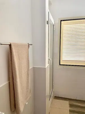 a bathroom with a shower and a towel at MaRiRa Apartments T1 in Santa Maria