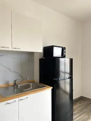 a kitchen with a black refrigerator and a sink at MaRiRa Apartments T1 in Santa Maria
