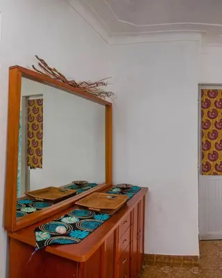 a bathroom with a mirror and a wooden dresser at Kasa Sirena in Tarrafal