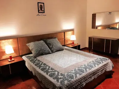 a bedroom with a bed with two lamps and a mirror at La Kaza du Soleil in Tarrafal