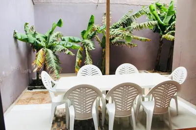 a white table and chairs in a room with plants at La Kaza du Soleil in Tarrafal