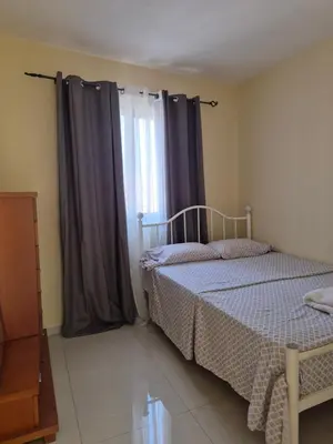 a bedroom with a bed and a window with curtains at Casa di Morabeza in Praia