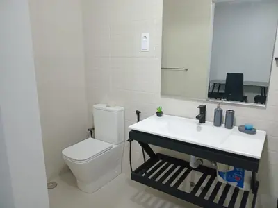 a bathroom with a toilet and a sink and a mirror at Abraço d Mindel in Mindelo