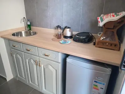 a kitchen with a counter and a sink and a dishwasher at Abraço d Mindel in Mindelo