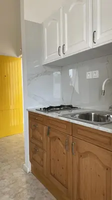 a kitchen with white cabinets and a sink at Apartament Salim in Beirona