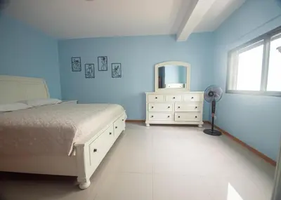 a bedroom with a bed and a tv and a dresser at Apartamentos Octane Mindelo in Mindelo