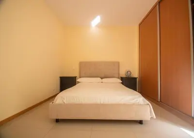 a bedroom with a large bed with two night stands at Apartamentos Octane Mindelo in Mindelo