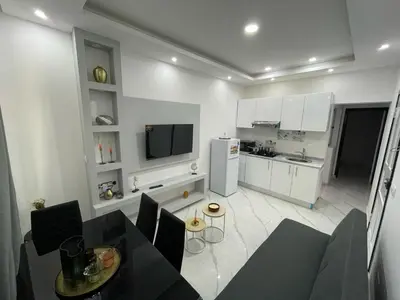 a kitchen with a dining table and a kitchen with a refrigerator at Di Rosa Apartament in Praia