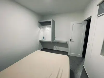 a white room with a bed and a closet at Di Rosa Apartament in Praia