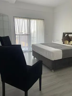 a bedroom with a bed and a chair and a window at Grace apartamento T2 in Praia