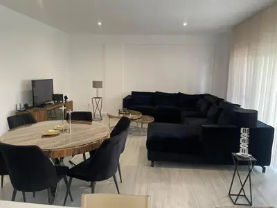 a living room with a black couch and a table at Grace apartamento T2 in Praia