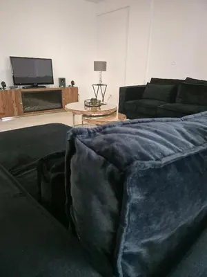 a living room with a black couch and a table at Grace apartamento T2 in Praia