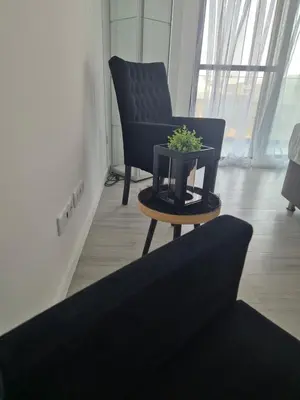 a black chair and a table with a plant on it at Grace apartamento T2 in Praia