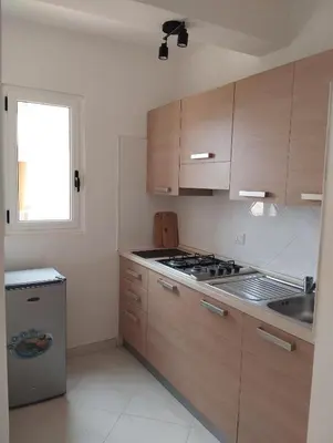 a kitchen with wooden cabinets and a stove and a window at Kite Sal in Santa Maria